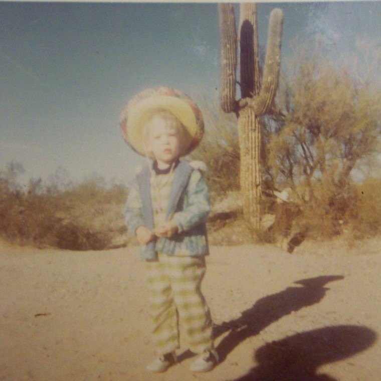 Dakota as a young child in a wide-brimmed hat